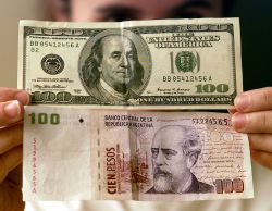 Un billete de 100 dólares y otro de 100 pesos argentinos.