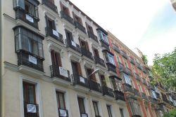 Fachada de edificios con carteles de pisos a la venta
