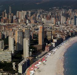 La playa de Poniente en la actualidad y un rascacielos en construcción.