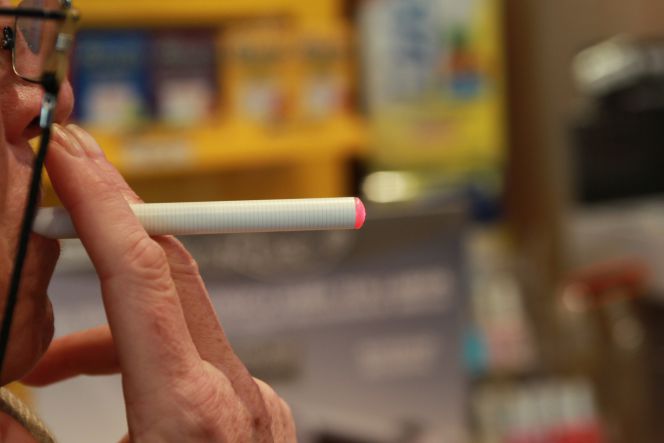 Una persona vapeando con un cigarrillo electrónico.