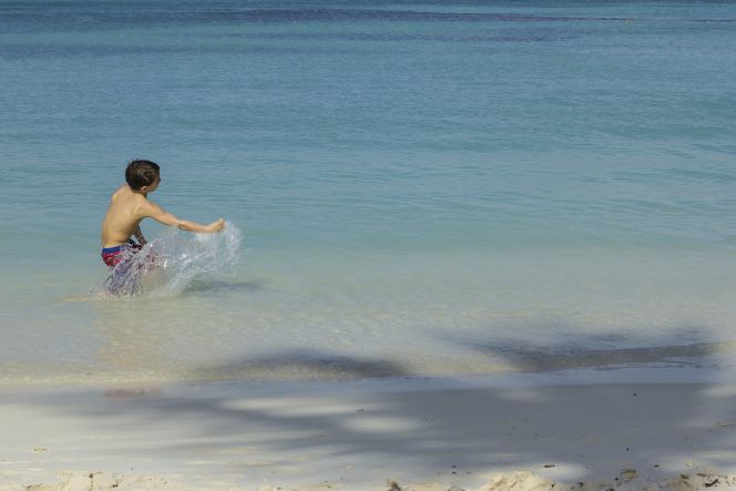 Un niño juega en una playa de Aruba.