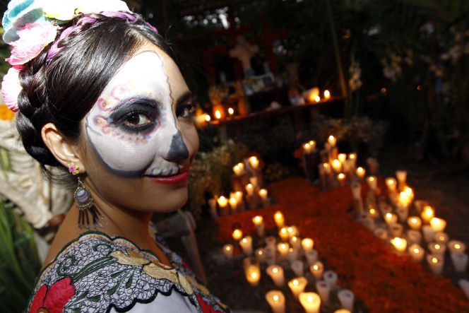 Las familias colocan velas sobre las tumbas de sus familiares para iluminar el camino de las ánimas en su vuelta a casa.