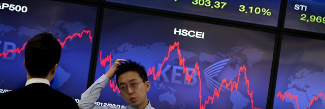 Corredores de bolsa conversan junto a una pantalla que muestra información bursátil en Seúl (Corea del Sur). EFEArchivo