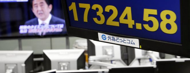 Un monitor de cotizaciones en Japón, con el primer ministro Shinzo Abe al fondo.
