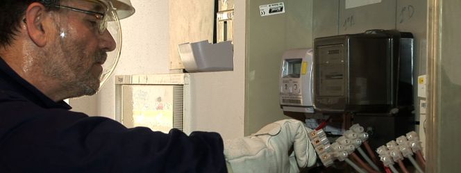 Un operario sustituye un contador eléctrico.