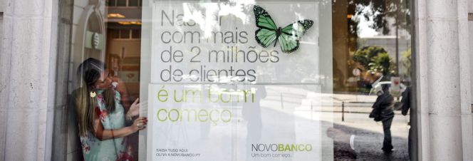 Un trabajador cambia el nombre y carteles del Banco Espírito Santo en una oficina de Lisboa (Portugal).