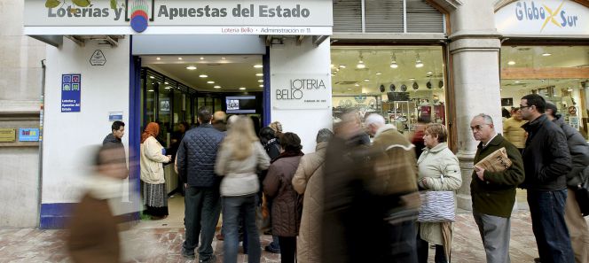 Cola para adquirir lotería frente a una administración de Valencia.