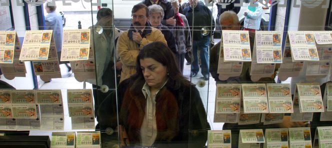 Compradores adquiriendo lotería en la ventanilla de una administración.