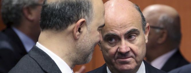 El ministro español de Economía, Luis de Guindos (derecha), habla con el comisario europeo de Economía y Finanzas, Pierre Moscovici (izquierda).