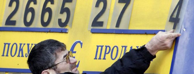 Un trabajador de una oficina de cambio coloca unas placas para formar las cifras del cambio dólar-rublo en Moscú, Rusia.
