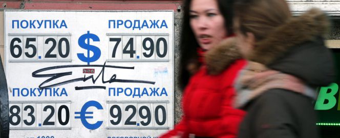Dos mujeres pasan por delante de una oficina de cambio de divisas ayer en Moscú, Rusia.
