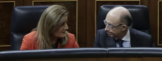 La ministra de Empleo, Fátima Báñez (i), charla con el ministro de Hacienda, Cristóbal Montoro (d), durante el Pleno en el Congreso de Los Diputados, esta mañana en Madrid.