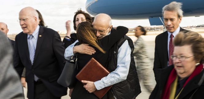Fotografía cedida por la Fuerza Aérea de los Estados Unidos donde se ve al contratista estadounidense Alan Gross abrazar a un familiar que lo esperaba a su regreso después de cinco años de cautiverio en Cuba, en la Base Aérea Andrews en Maryland (EE UU)