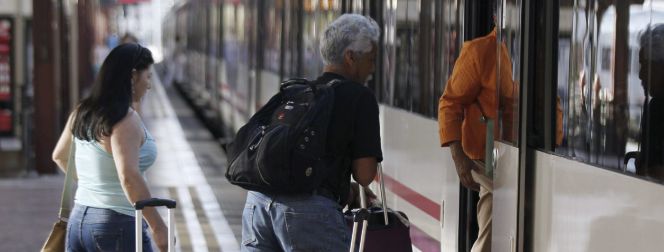 Varias personas montan a un tren en la estación de Chamartín, en Madrid.