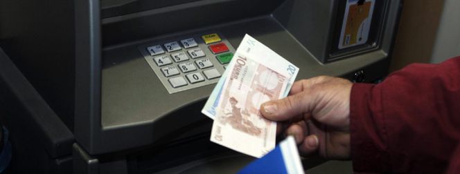 Un hombre retira euros de un cajero automático.