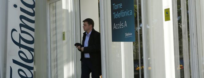 Un hombre sale de un edificio de Telefónica en Barcelona.