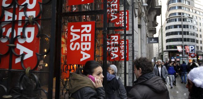 Varias personas ante un comercio en rebajas en la Gran Vía de Madrid.