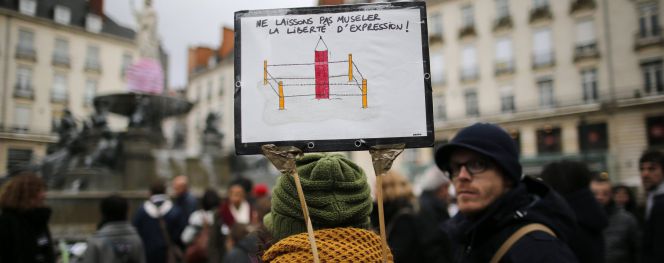 Una mujer sostiene una pancarta que reza "No amordaces la libertad de expresión" en una manifestación en nantes.