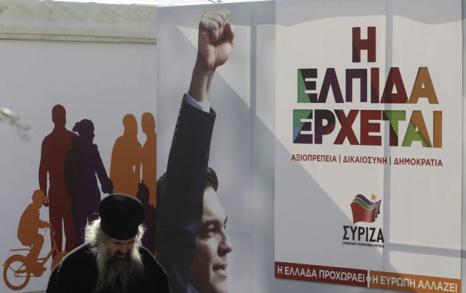 Un sacerdote ortodoxo camina delante de una caseta del principal partido de la oposición, el izquierdista Syriza, en el centro de Atenas, Grecia.