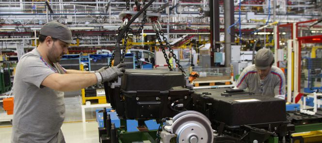 Dos operarios colocan las baterías de la furgoneta eléctrica Citroën Berlingo en la cadena de montaje de la planta de PSA.