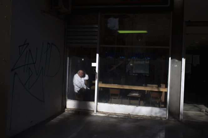 Un barbero en Atenas, a la espera de clientes.