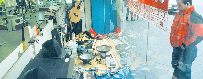 Un hombre mira en el escaparate de una tienda de segunda mano.