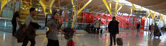 Varios pasajeros pasan ante la zona de acceso al Puente Aéreo, en la terminal 4 de Barajas.