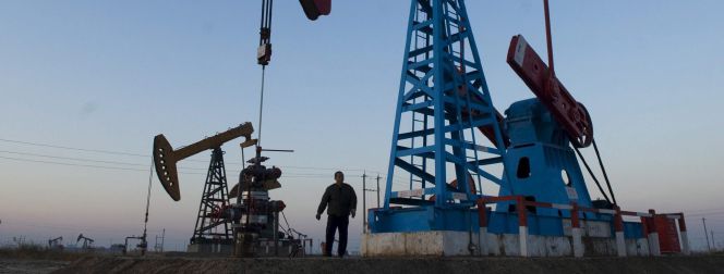 Imagen de archivo de un trabajador bajo un pozo de petróleo