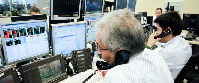 Los agentes de Ahorro Corporación, grupo de servicios financieros encargado de la subasta de bonos y letras del Tesoro Público.