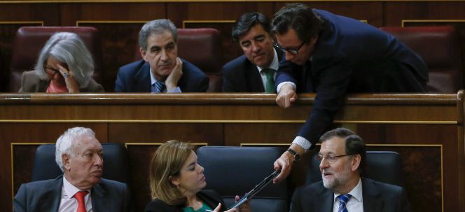 El vicesecretario de Organización del PP, Carlos Floriano, entrega una carpeta a la vicepresidenta del Gobierno, Soraya Sáenz de Santamaría, en presencia del presidente del Gobierno, Mariano Rajoy y el ministro de Exteriores, José Manuel García-Margallo.