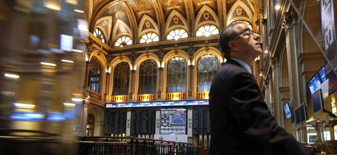 Un inversor consulta las pantallas del Palacio de la Bolsa de Madrid