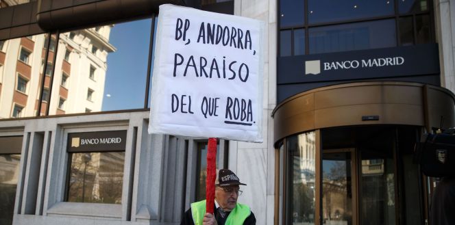 Un hombre protesta frente a la sede de Banco Madrid, en la capital española.