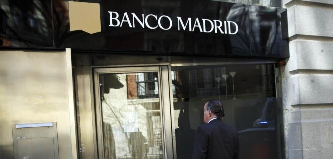 Un hombre frente a la sede de Banco Madrid.
