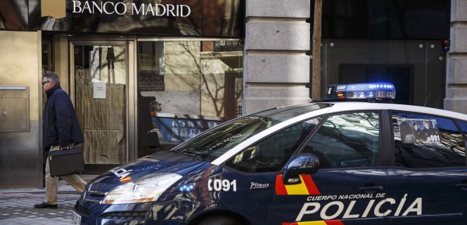 Un coche de policía aparcado frente a la oficina de Banco Madrid.