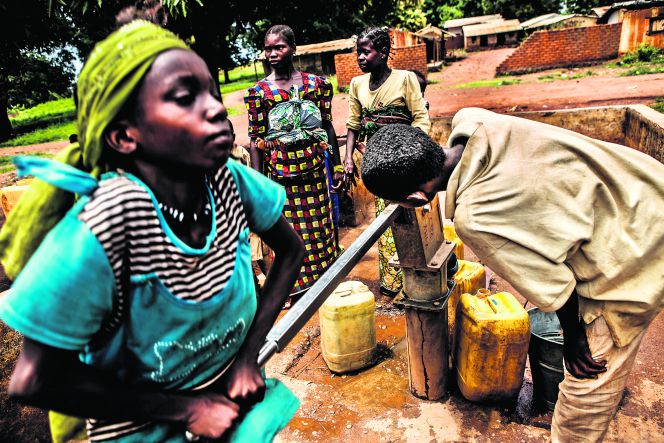 Niños nigerianos sacan agua de una fuente en el distrito Madaoua, al sur del país.