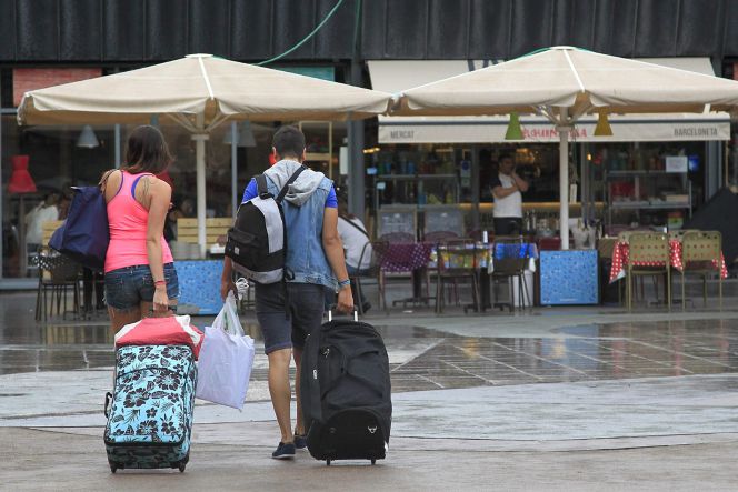 Unos turistas caminan con sus maletas por el barrio de La Barceloneta. EFEArchivo