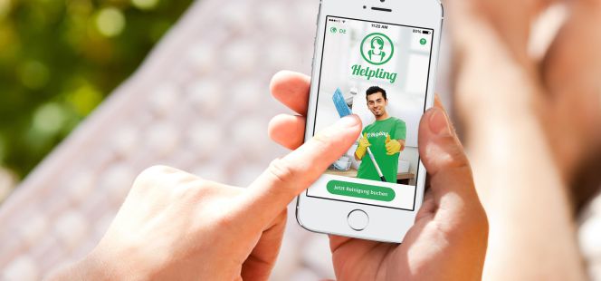 Una persona accede a la app de Helping desde el móvil para buscar un profesional de la limpieza.