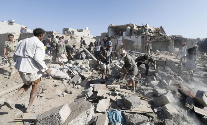 Ciudadanos buscan supervivientes entre los escombros tras un ataque aéreo en las proximidades del aeropuerto de Sanáa, Yemen.