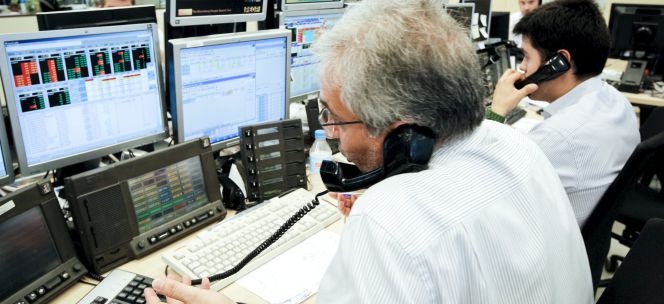 Los agentes de Ahorro Corporación, grupo de servicios financieros encargado de la subasta de bonos y letras del Tesoro Público.