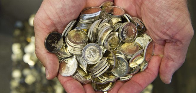 Un hombre sostiene varias monedas de euro. EFEArchivo