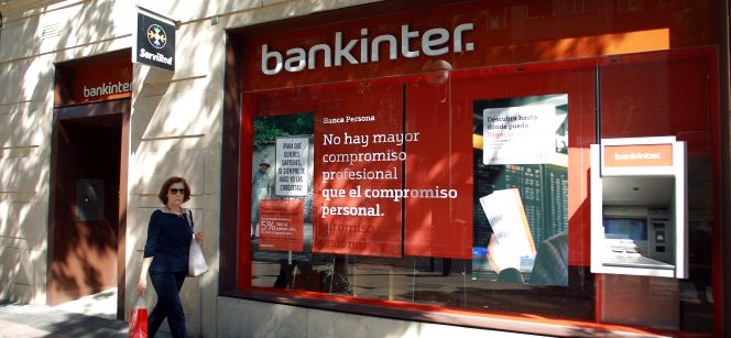 Una mujer camina frente a una sucursal de Bankinter.
