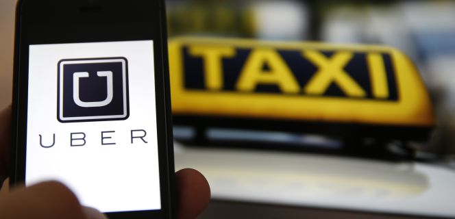 Un usuario utiliza la aplicación Uber, un servicio que compite con los taxis tradicionales.