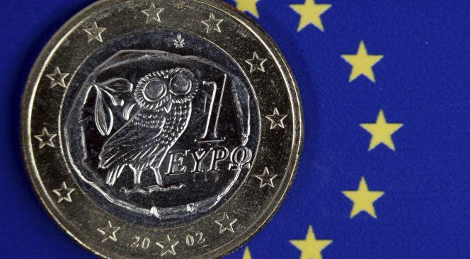 Una moneda de euro griego permanece sobre el emblema de la Unión Europea.