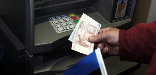 Un hombre retira euros de un cajero automático.