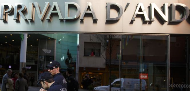 Dos policías caminan frente a la sede de BPA, en Andorra.