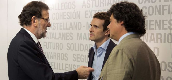 El presidente del Gobierno, Mariano Rajoy, que conversa con el vicesecretario de Comunicación, Pablo Casado, y el futuro director de campaña para las elecciones generales, Jorge Moragas.