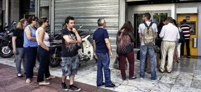 Un grupo de personas hace cola ante un cajero automático de un banco griego, en Atenas, tras la imposición de un corralito por parte del Gobierno.