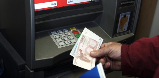 Un hombre retira euros de un cajero automático.