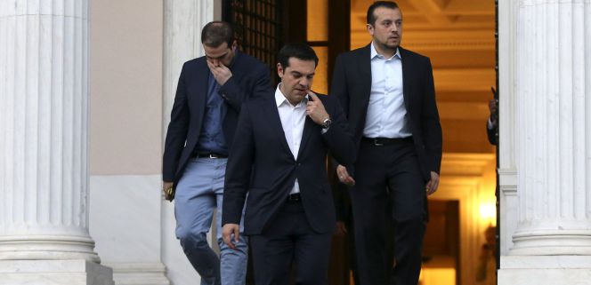 El primer ministro griego, Alexis Tsipras, flanqueado por el ministro de Presidencia Nikos Pappas (derecha) y el portavoz Gabriel Sakelaridis, abandona sus oficinas para visitar al presidente Prokopis Pavlopoulos, ayer en Atenas.