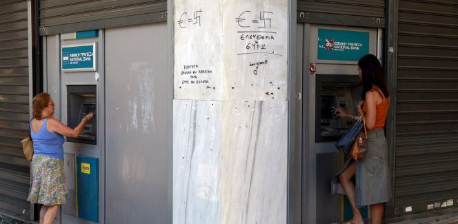 Dos ciudadanas sacan dinero de un cajero automático en Atenas.